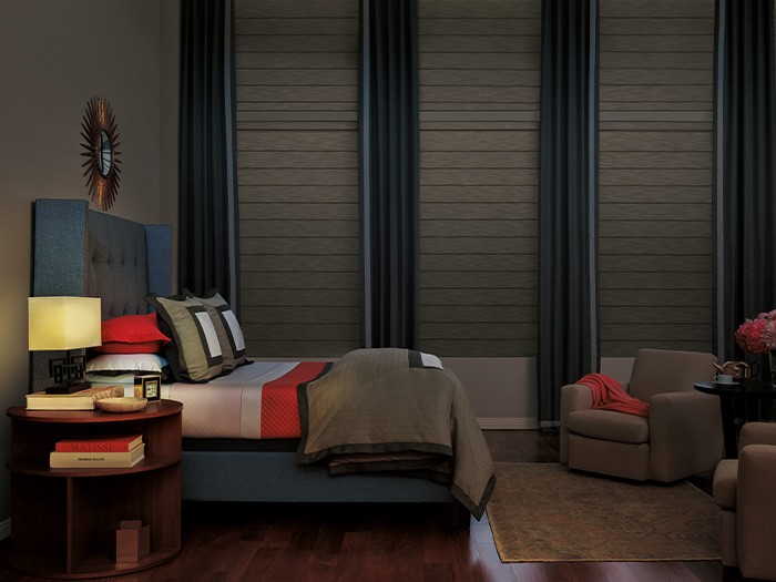 Dark bedroom with tall windows featuring Vignette® Modern Roman Shades.